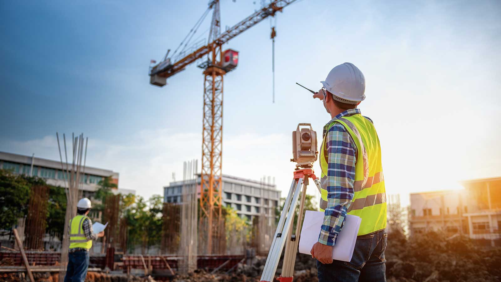 مهندس عمران با نقشه‌های پروژه در یک سایت ساختمانی