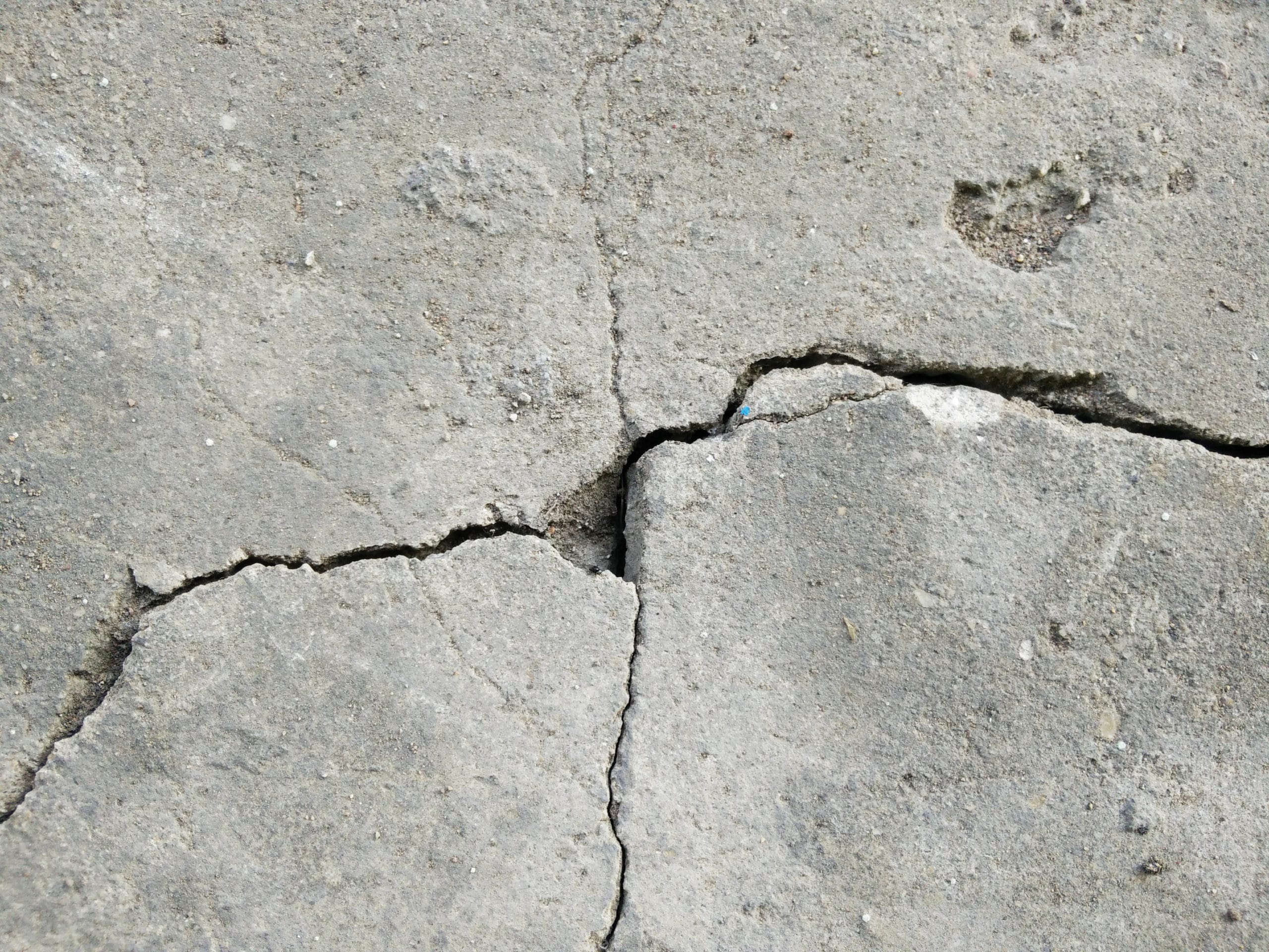 تصویر یک ترک عمیق در کف بتنی یک کارخانه صنعتی